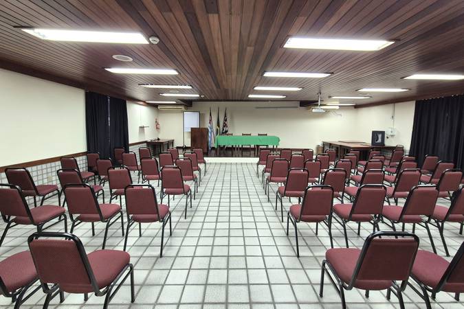 Sala de eventos com cadeiras e palco